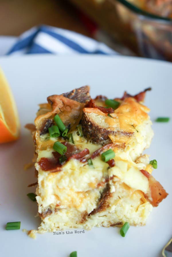 Bacon, Egg & Cheese Strata - slice of strata on plate with orange slices.