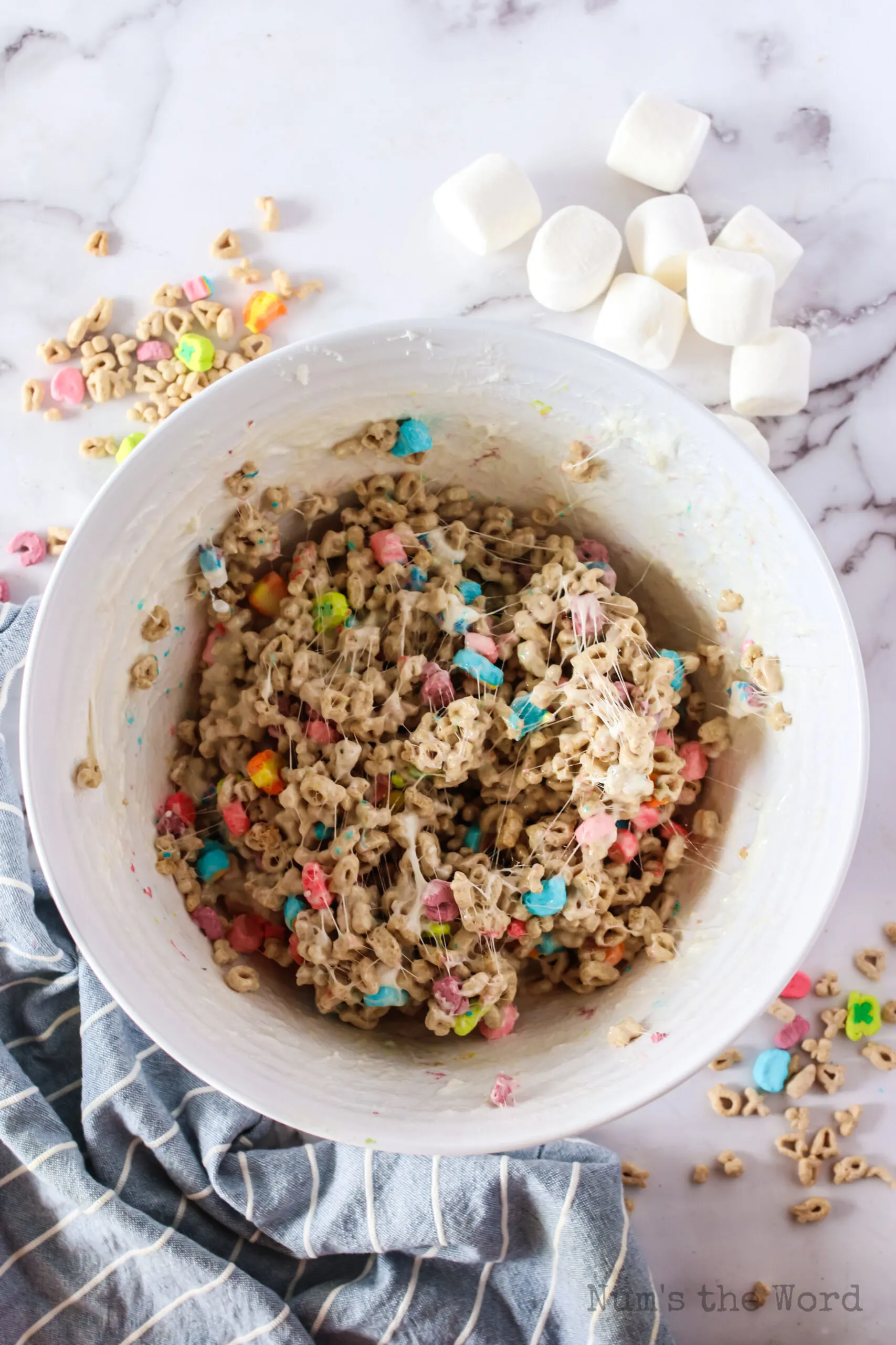 marshmallows and lucky charms in a bowl mixed and ready to spread in a pan