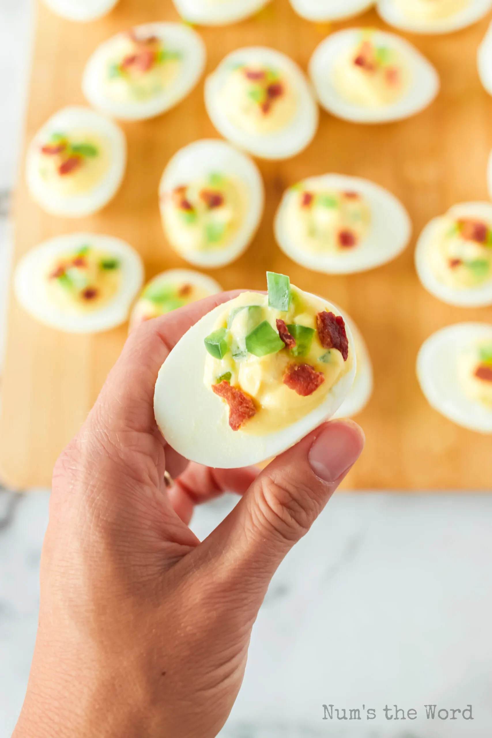 hand holding a deviled egg close to the camera