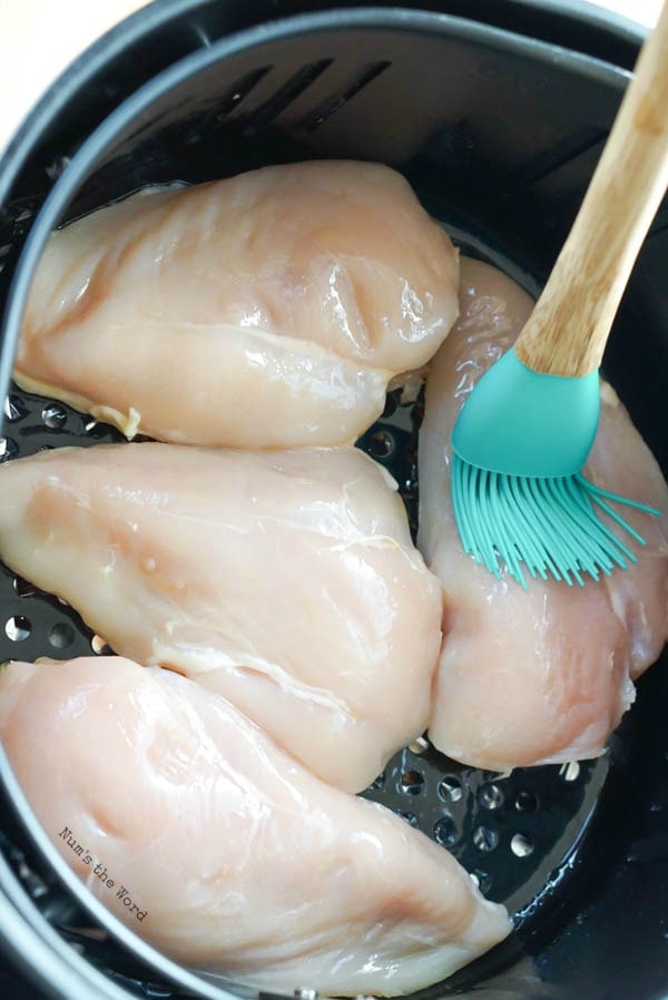 Air Fryer Chicken Breasts - olive oil being brushed onto breasts