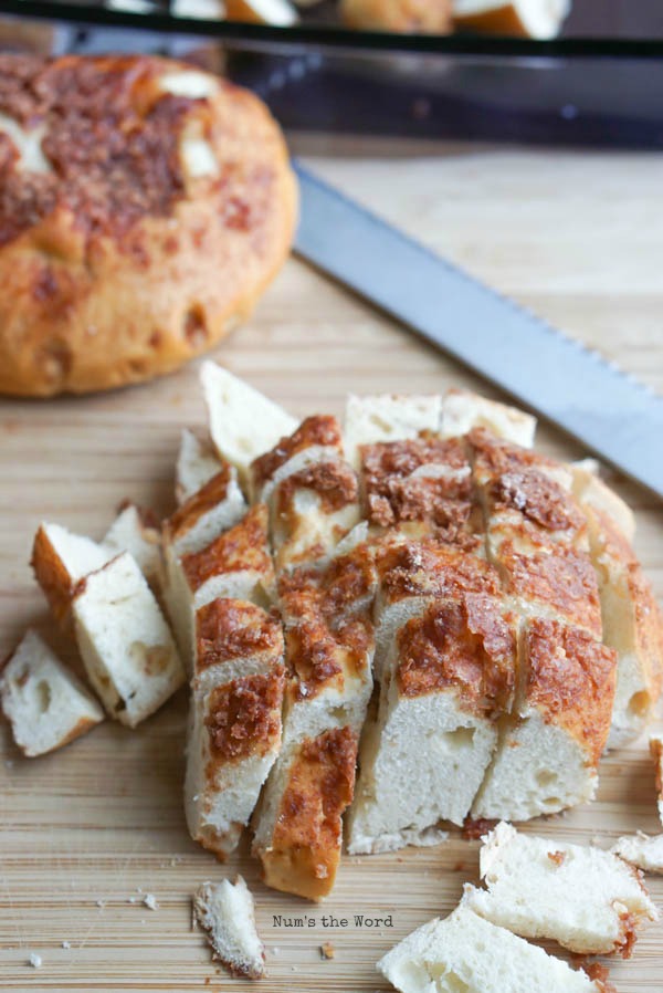 Bagels being cut up into bite sized pieces.