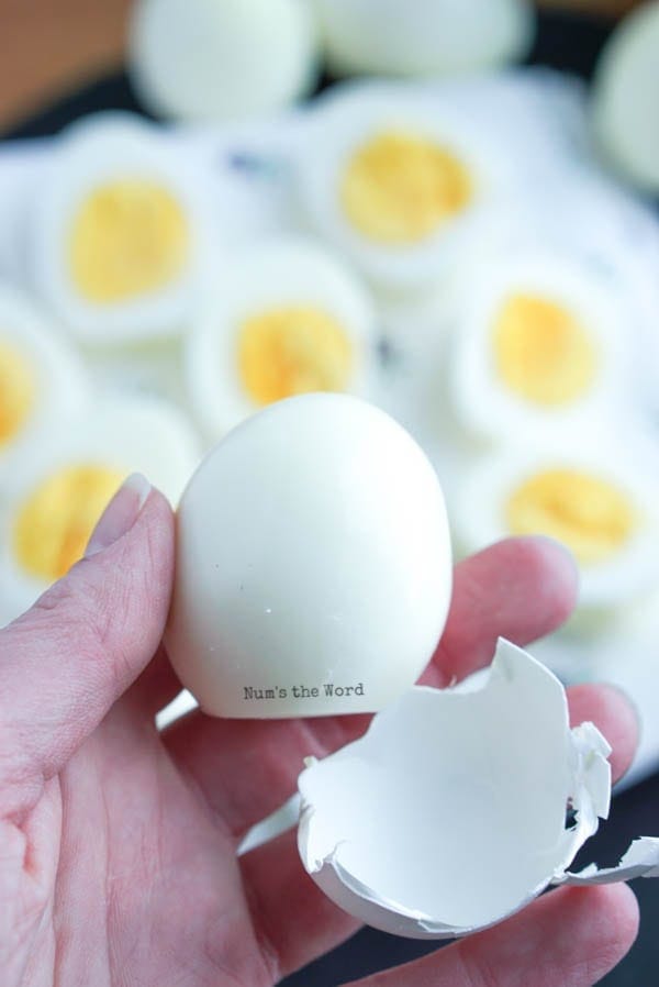 Air Fryer Hard Boiled Eggs - hand holding hard boiled egg in front of camera with shell to show how easy they are to peel.