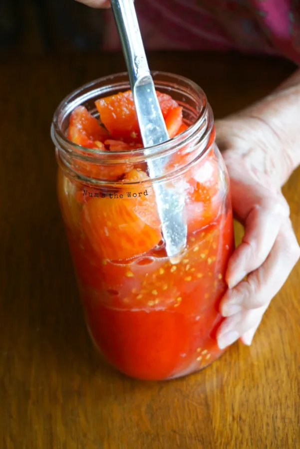 knife placed into canning jars to press out any air bubbles