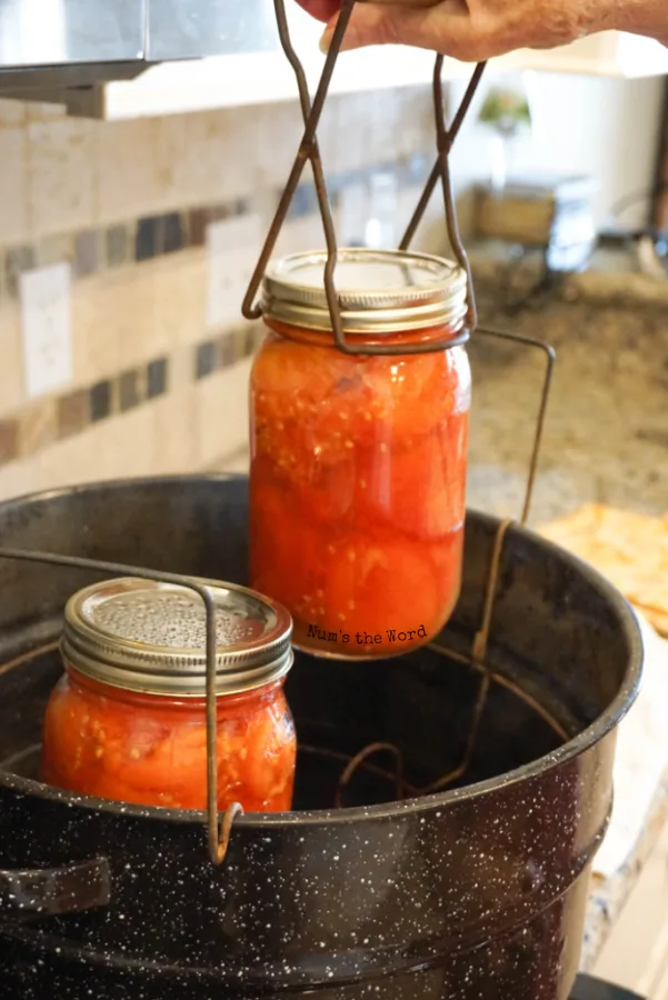 Lifting a canning jar out of the canner