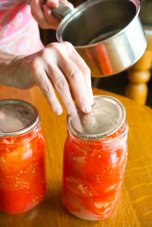 placing the lids on a mason jars