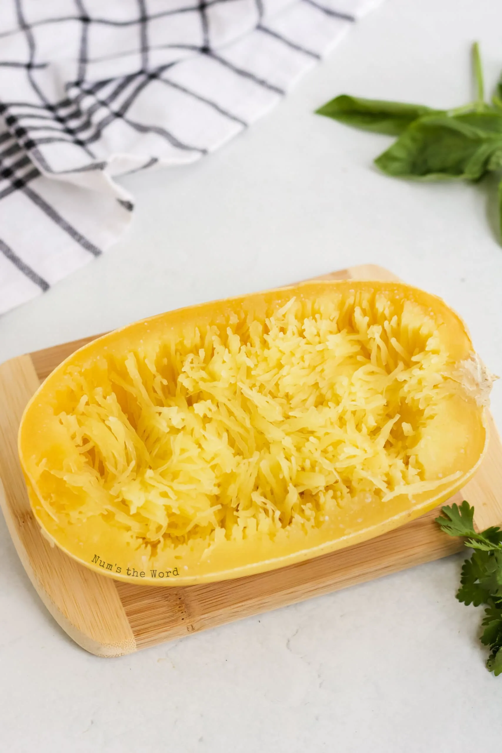 cooked spaghetti squash being pulled into thin spaghetti strands