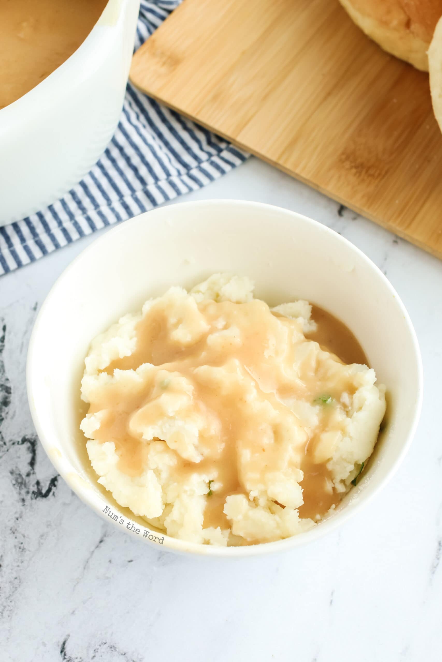a bowl of mashed potatoes with gravy poured over.