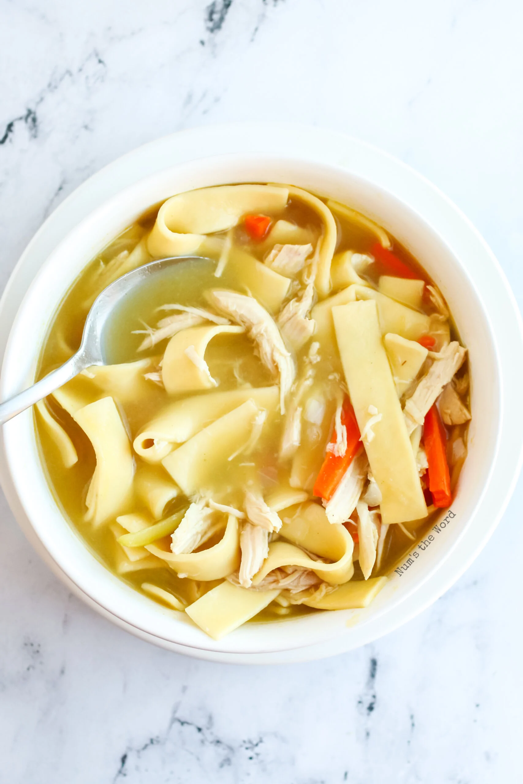 top view image of soup with a spoon in it ready to eat