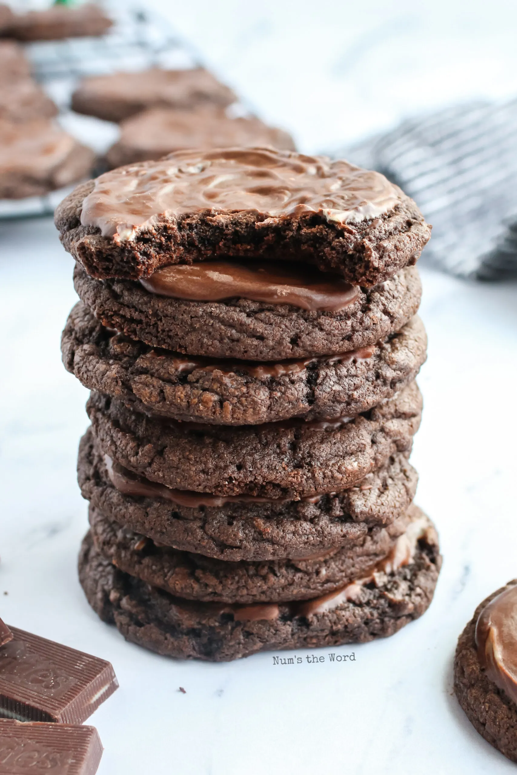 stack of 7 cookies on a counter with top cookie with a bite taken out.