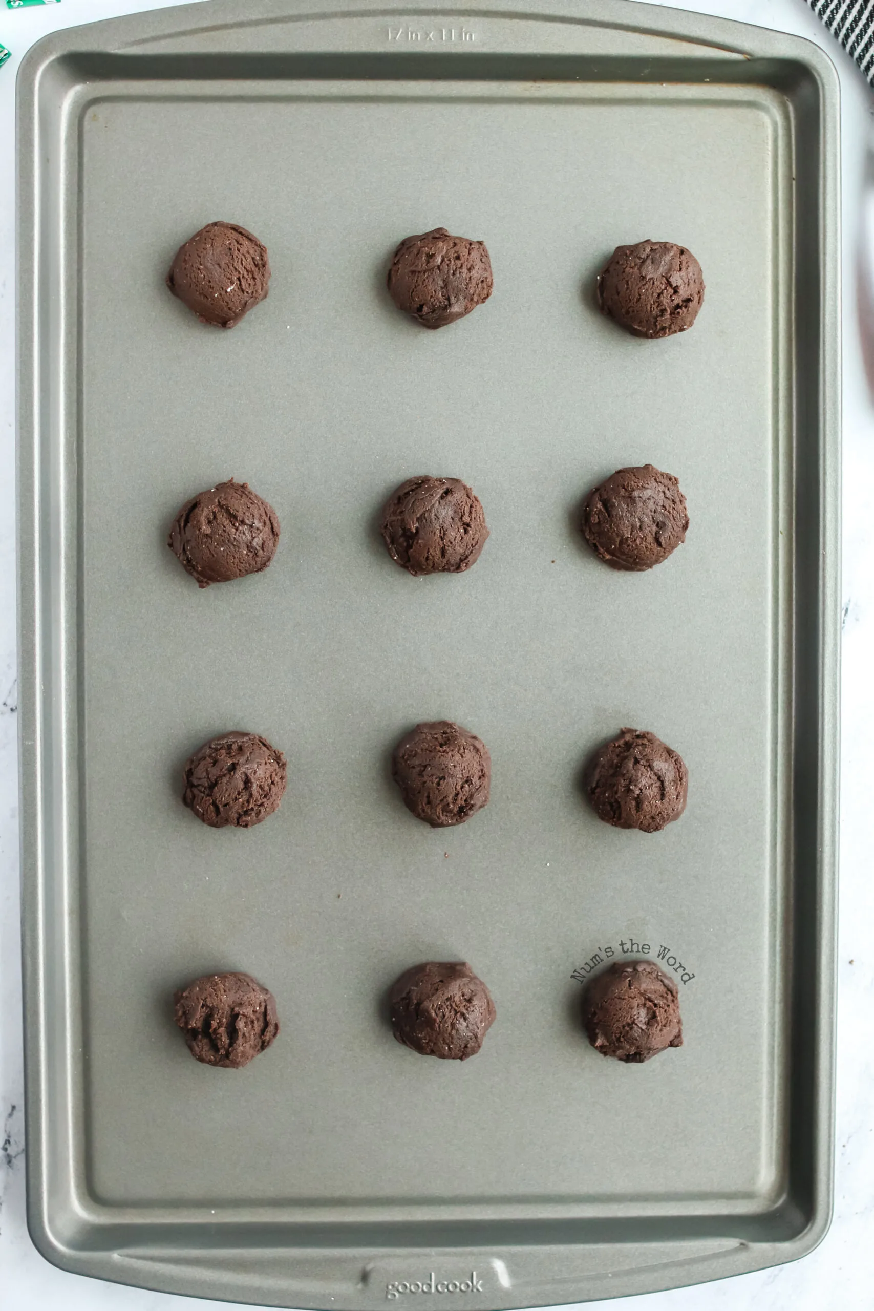 cookie sheet with 12 dough balls ready to be baked.