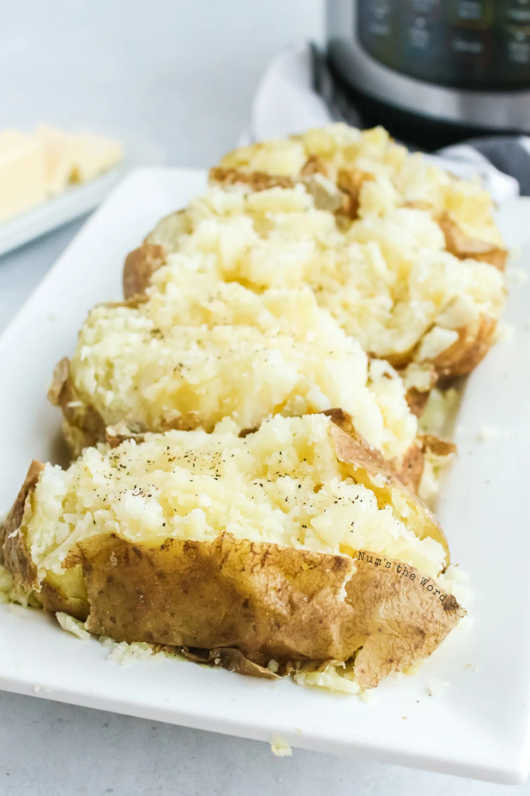 close up of 4 baked potatoes, cooked, fluffed and ready to be eaten