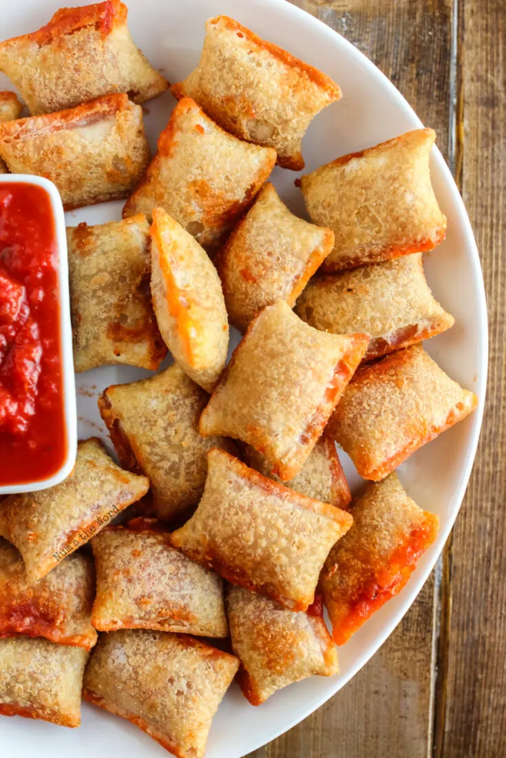 top view of pizza rolls on plate with marinara sauce