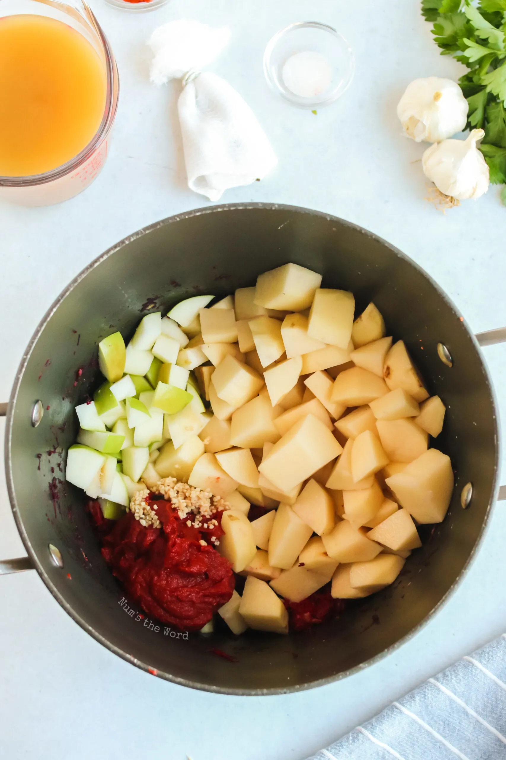 apples, potatoes, tomato paste, garlic added to pot.