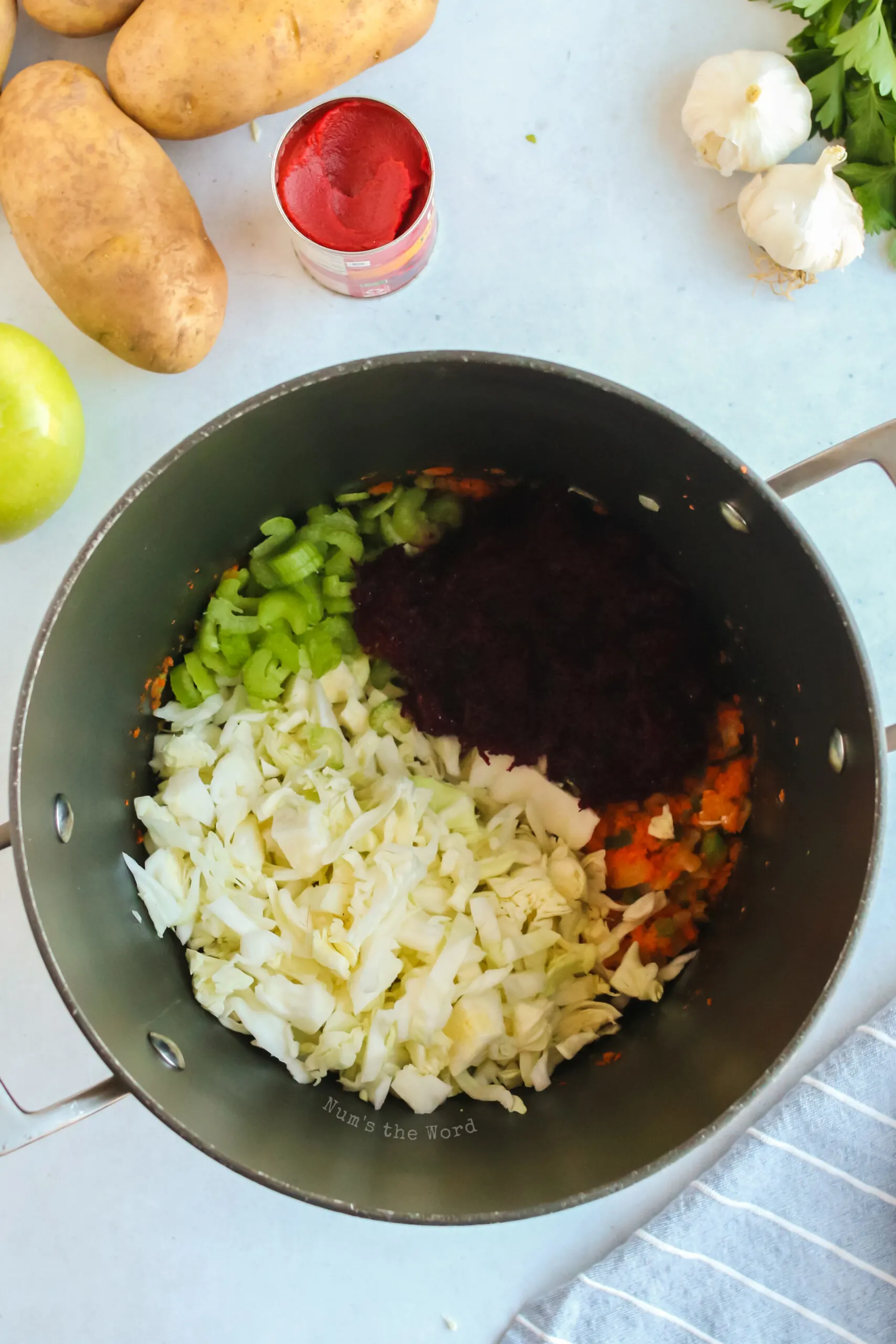 Cabbage, beet and celery added to butter mixture in borscht pot