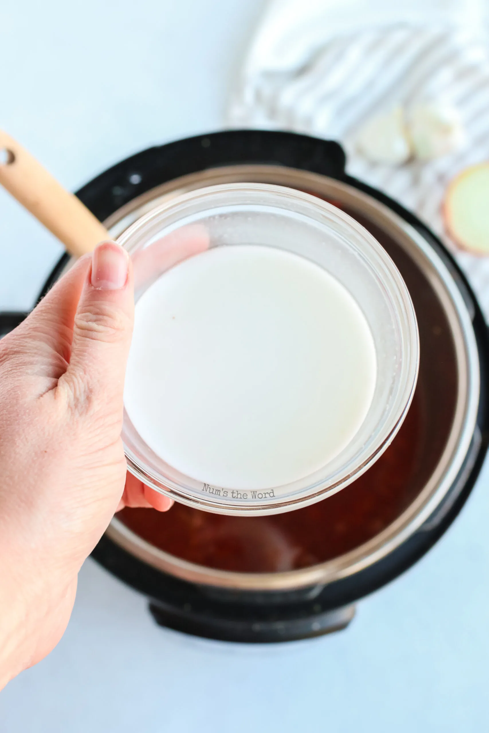 corn starch mixture being poured into instant pot to thicken the beef paprikash sauce.