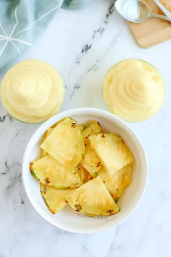 Bowl of fresh pineapple with two cups of dole whip