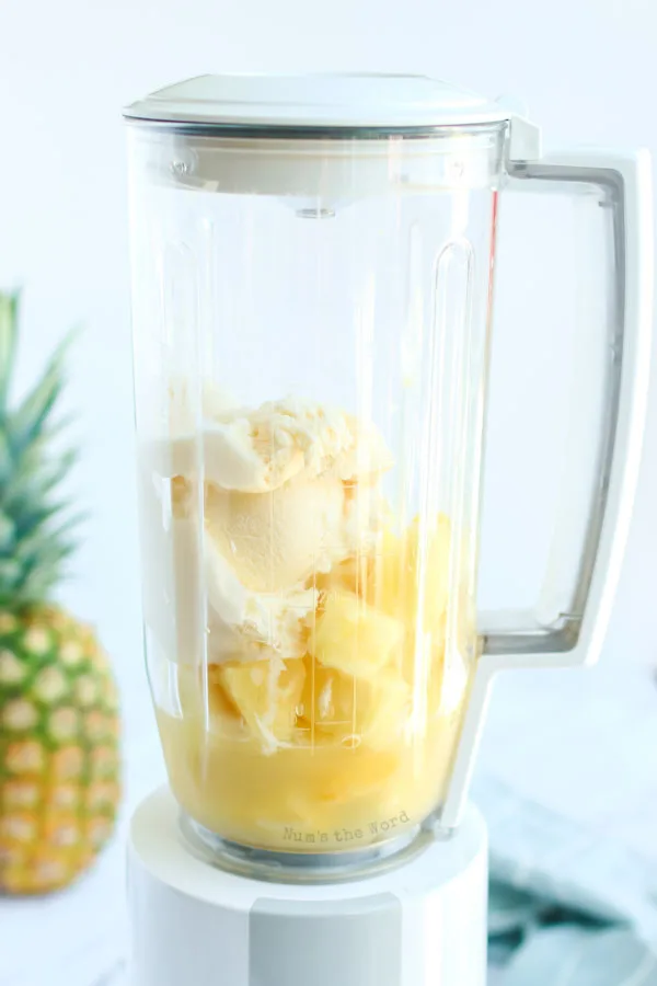 ice cream pineapple juice and frozen pineapple in a blender, unmixed