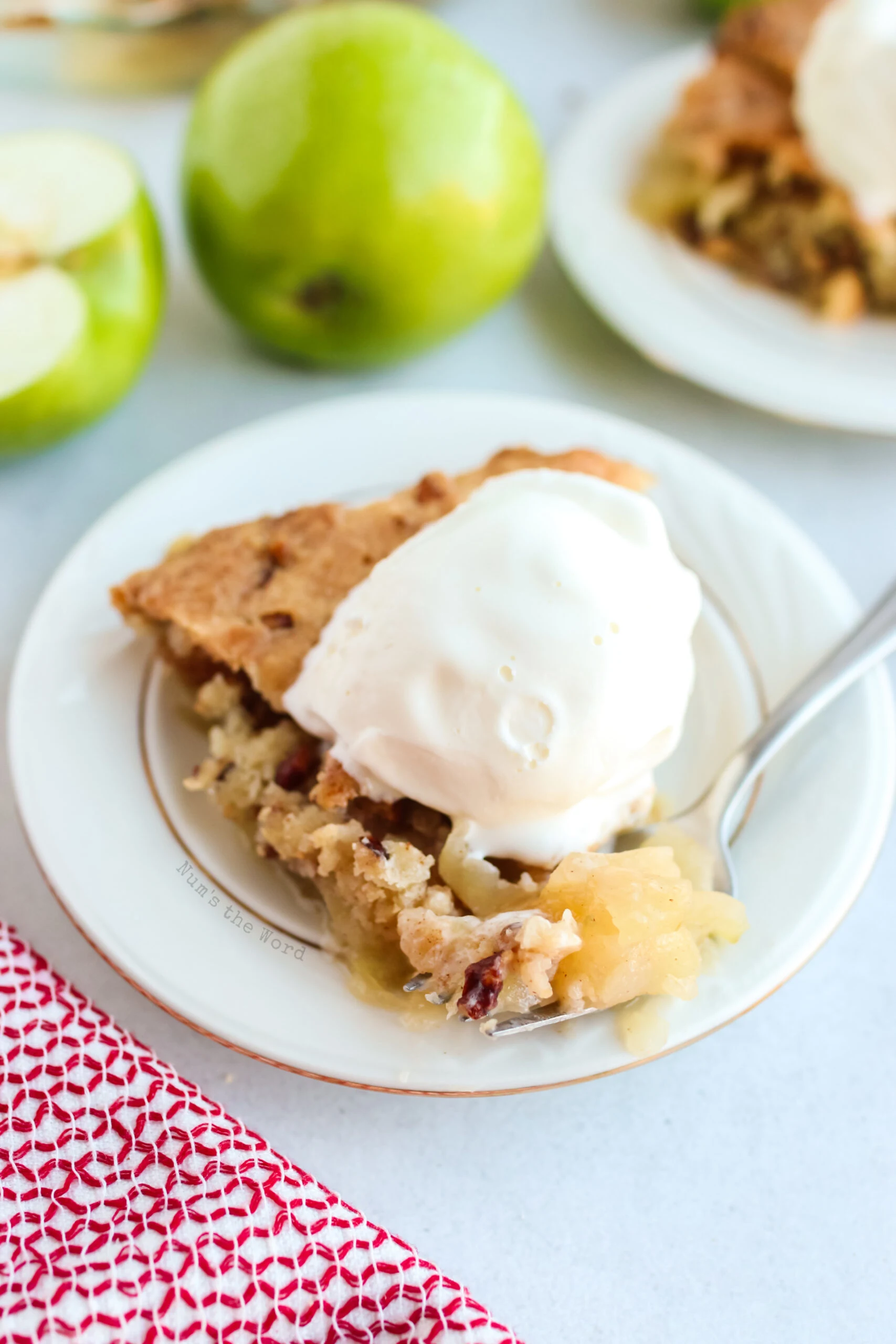 zoomed in image of single slice of swedish apple pie with scoop of ice cream on plate.