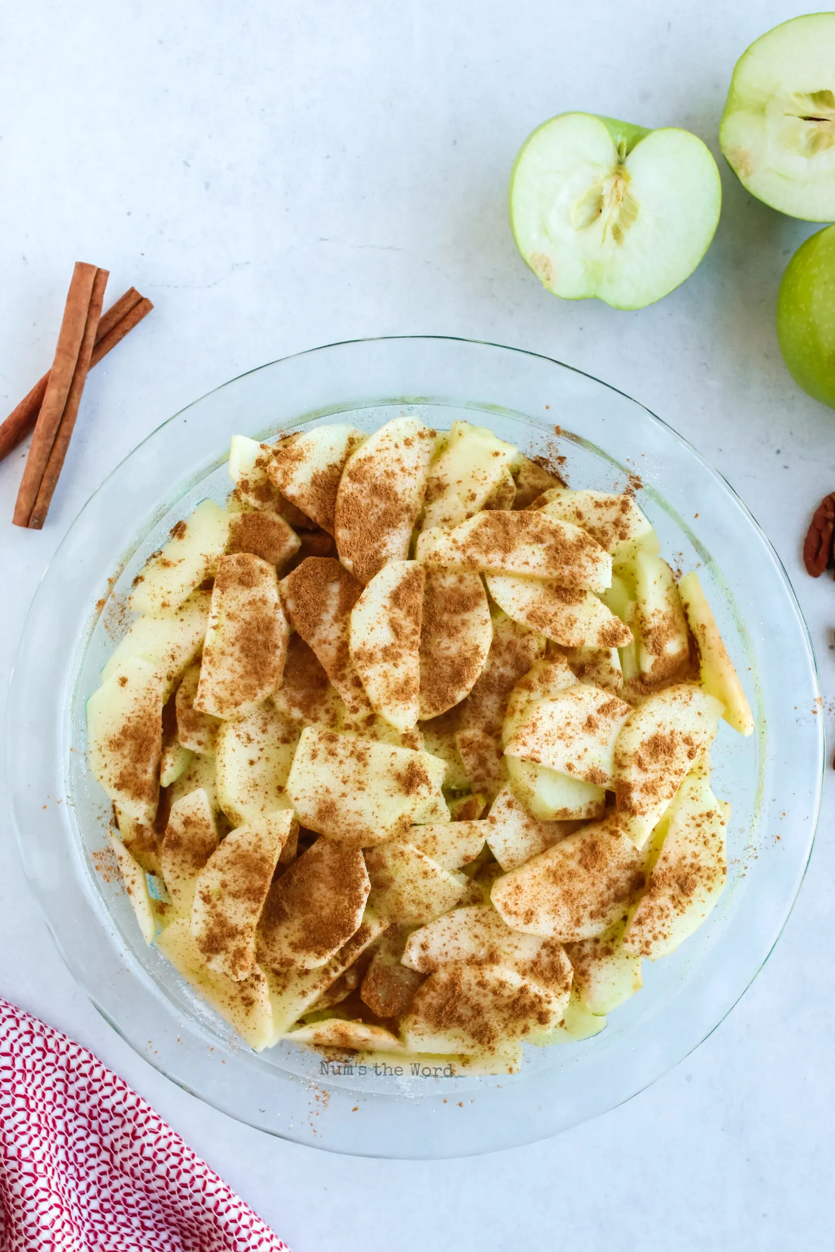 Cinnamon and Sugar sprinkled on top of apple slices in pie plate