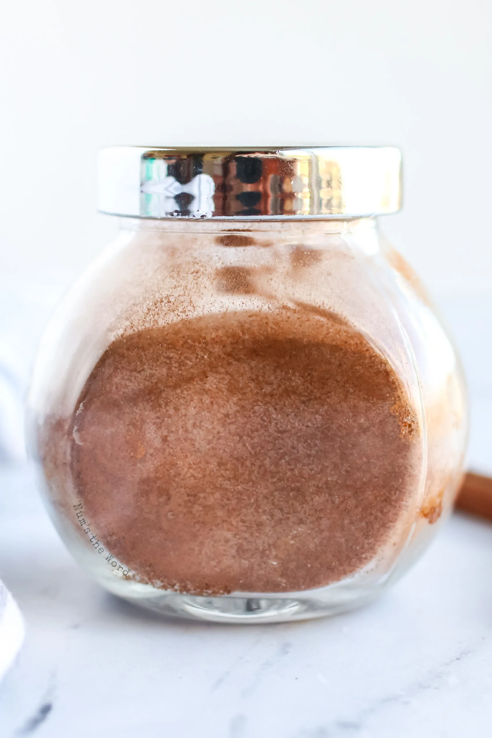 jar of cinnamon sugar with lid on, side view