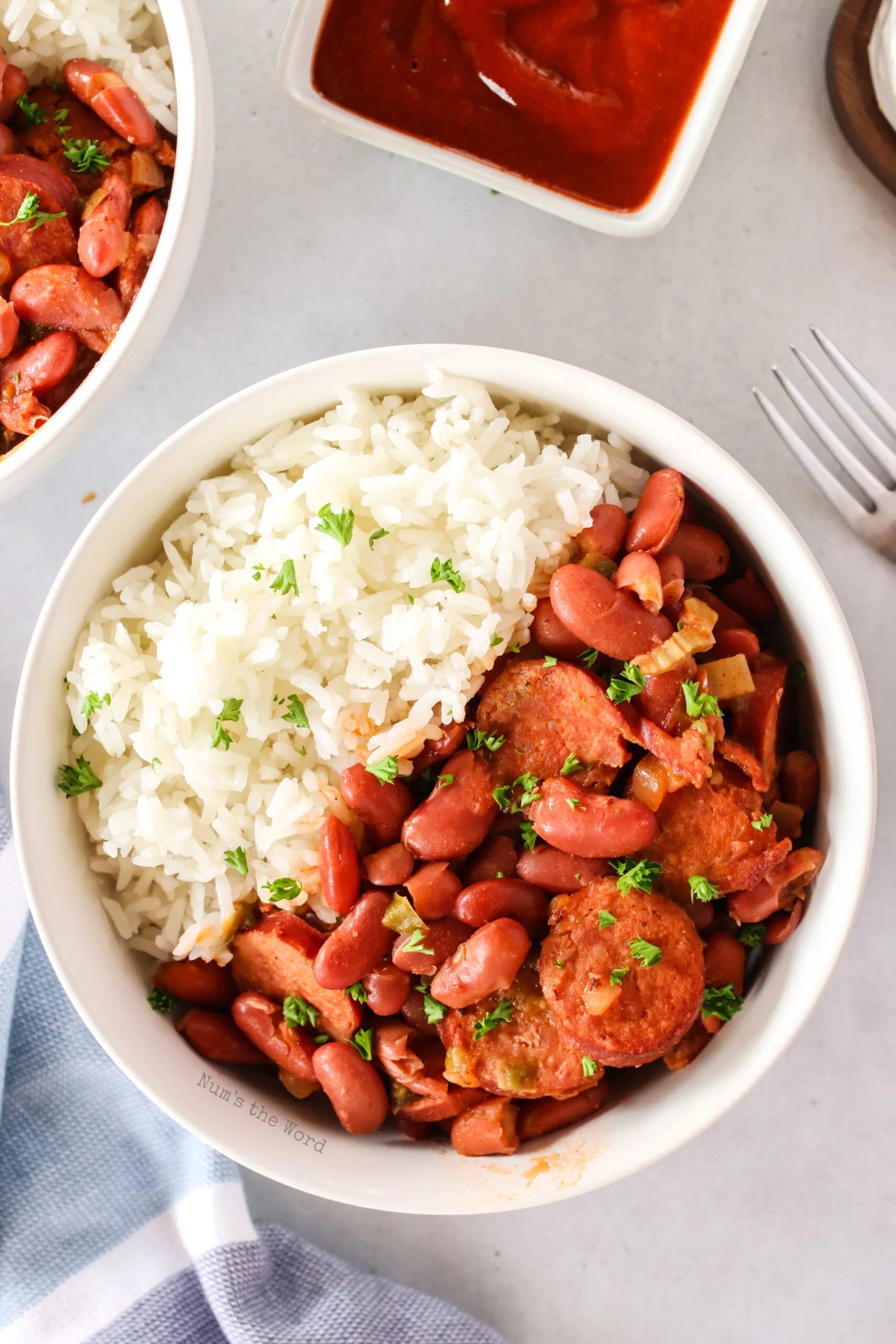 red beans and rice, cooked and in a bowl with rice. Image is taken from the top looking down.