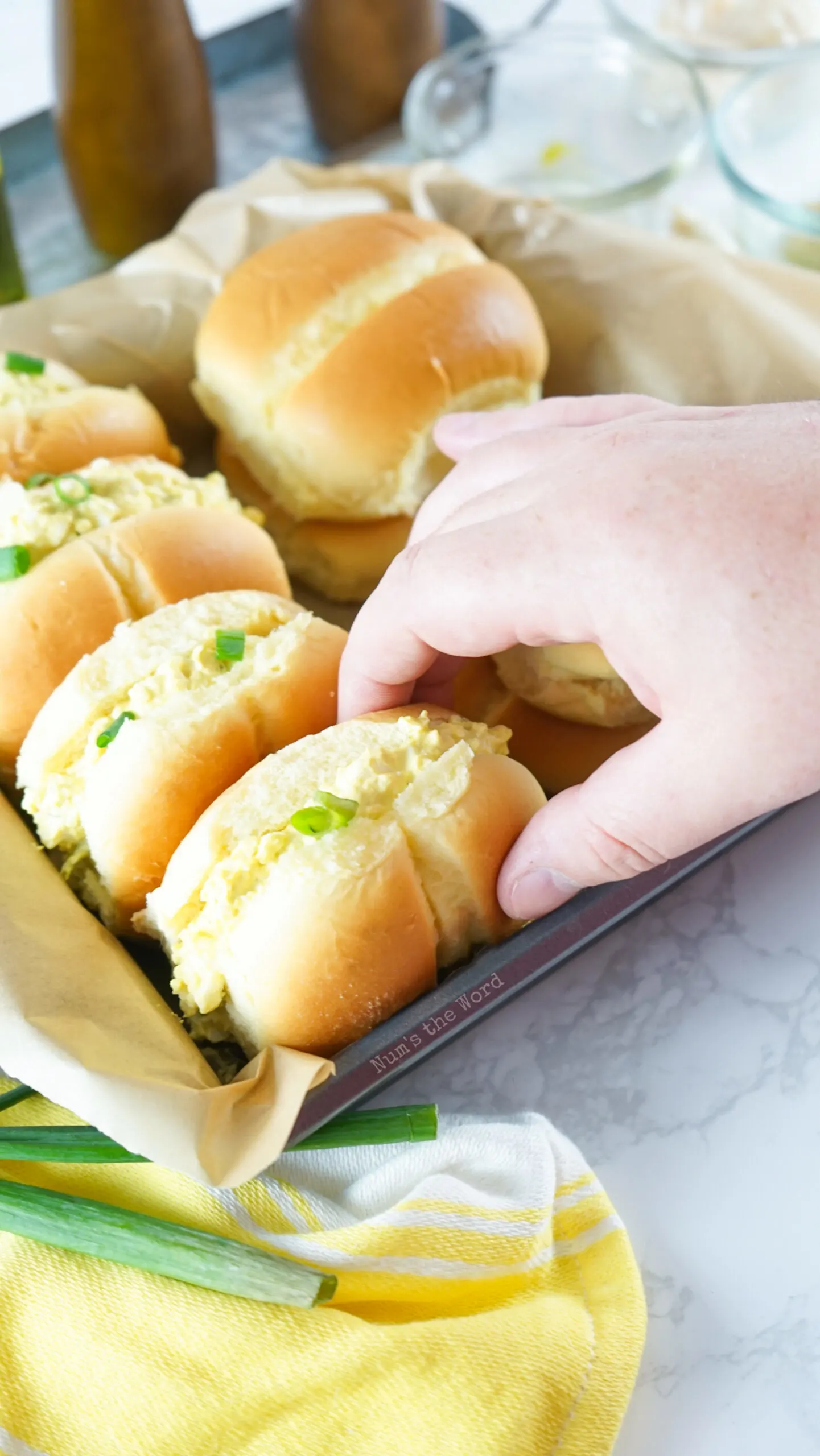 Sandwiches set out with a hand reaching for one