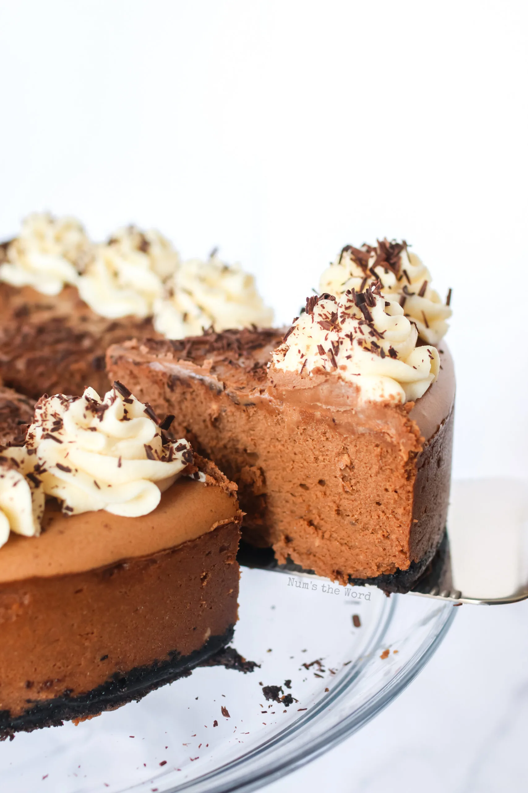 a slice of cheesecake on a serving fork, being removed from whole cheesecake.