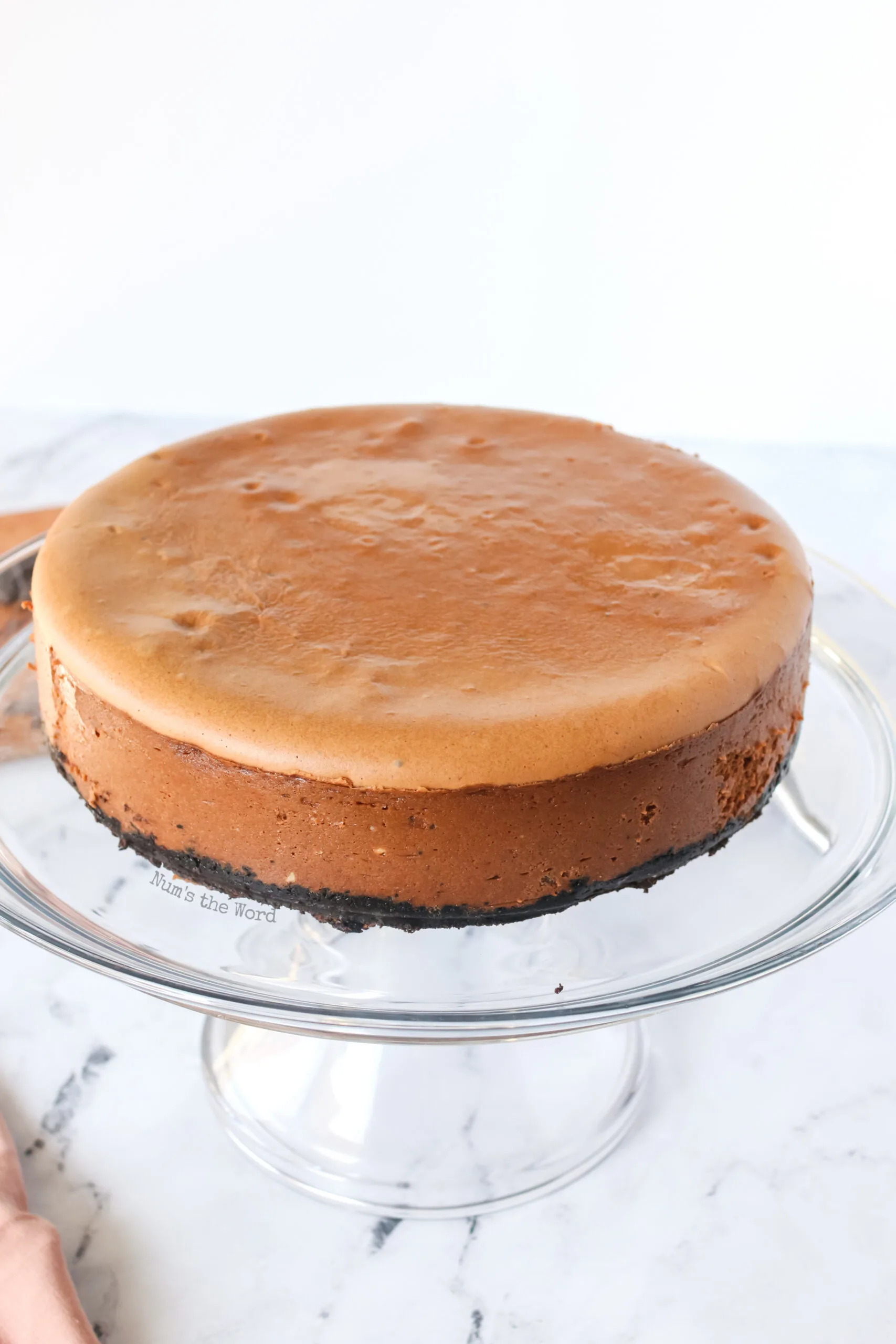 baked and cooled cheesecake on a serving platter.