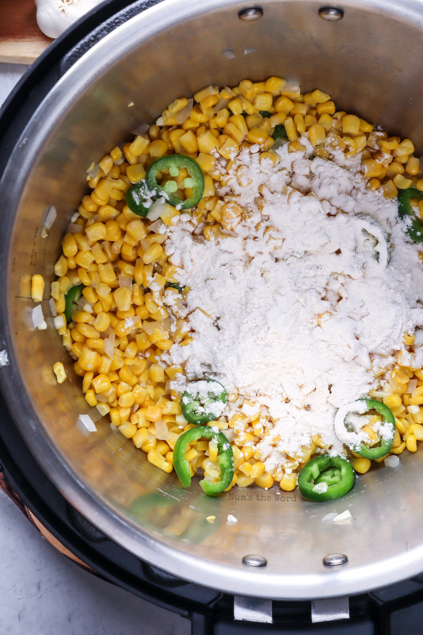 Onion, jalapeno, garlic, corn, flour and elote seasoning added to butter. 