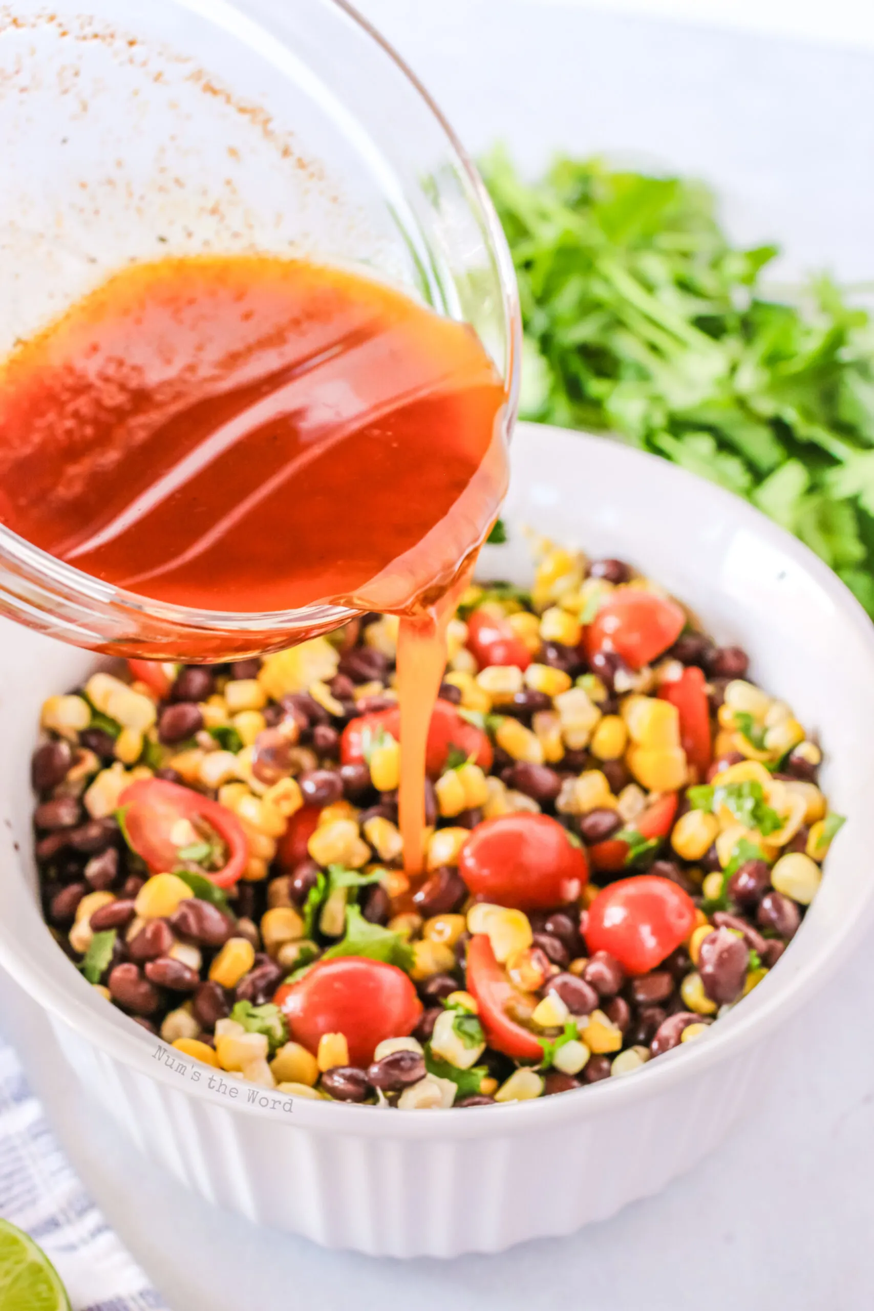 dressing is mixed and being poured over corn salad.