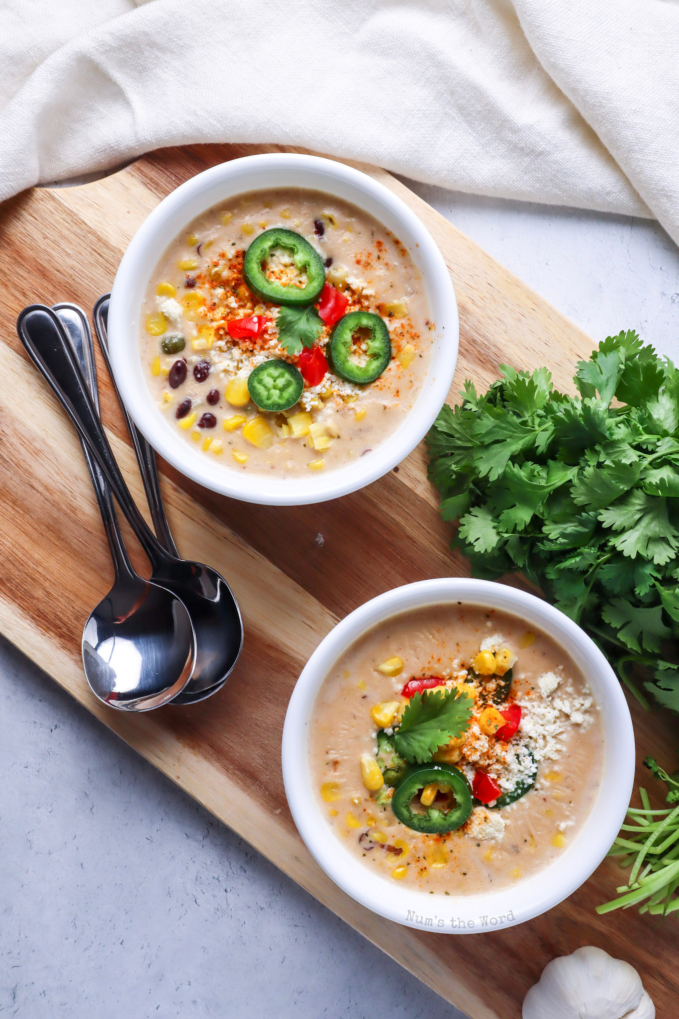 Top view looking down at two bowls of soup with toppings added. 