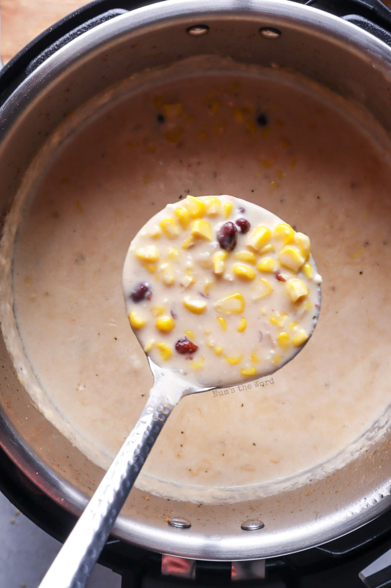 soup cooked with a large serving spoon holding out a serving, ready to dish up.