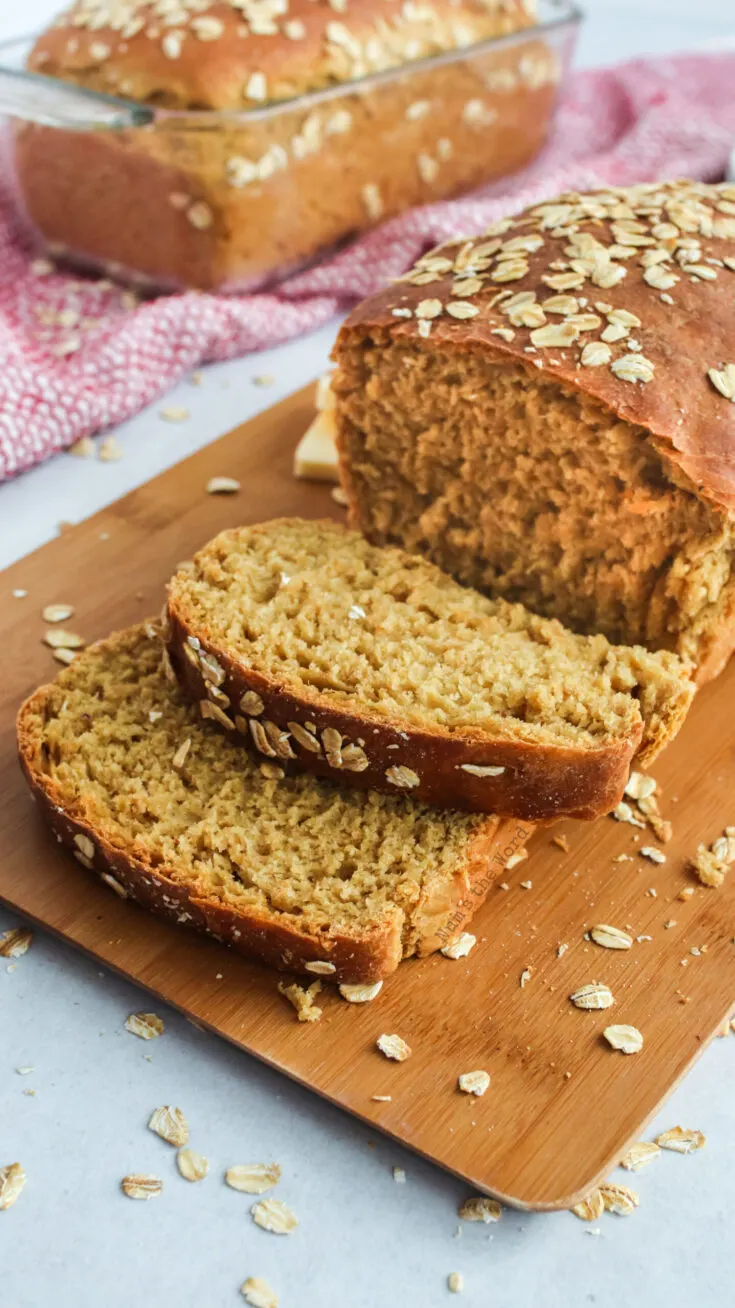 loaf of bread on cutting board with two slices cut from it.