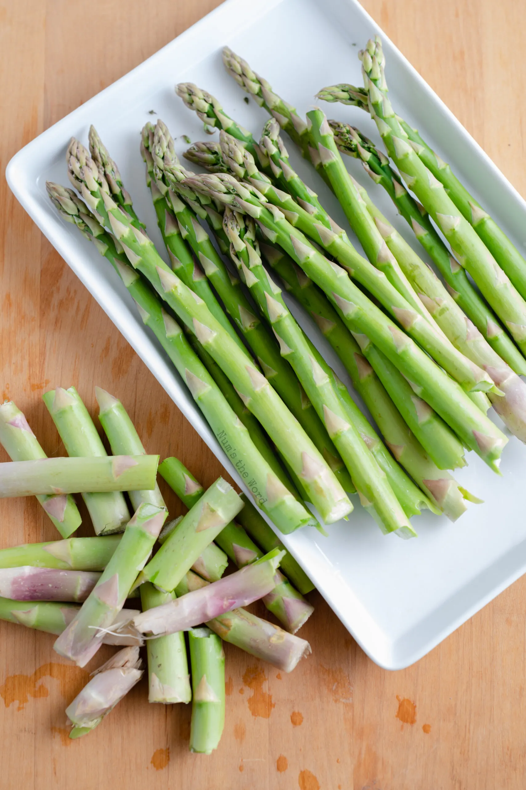 Asparagus on a plate with ends snapped off.