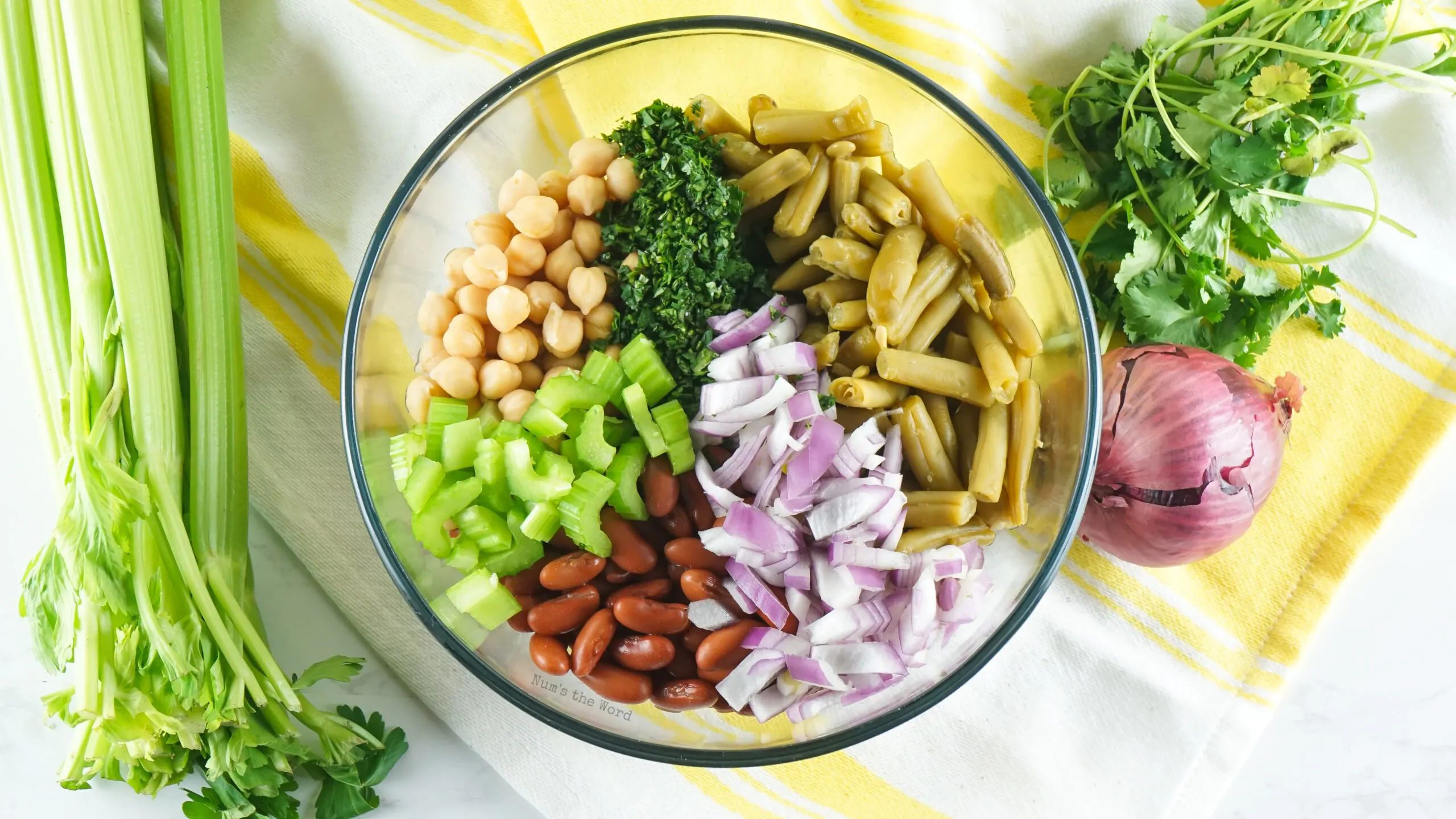 green beans, kidney beans, garbanzo beans, red onion, celery, and cilantro added to a bowl