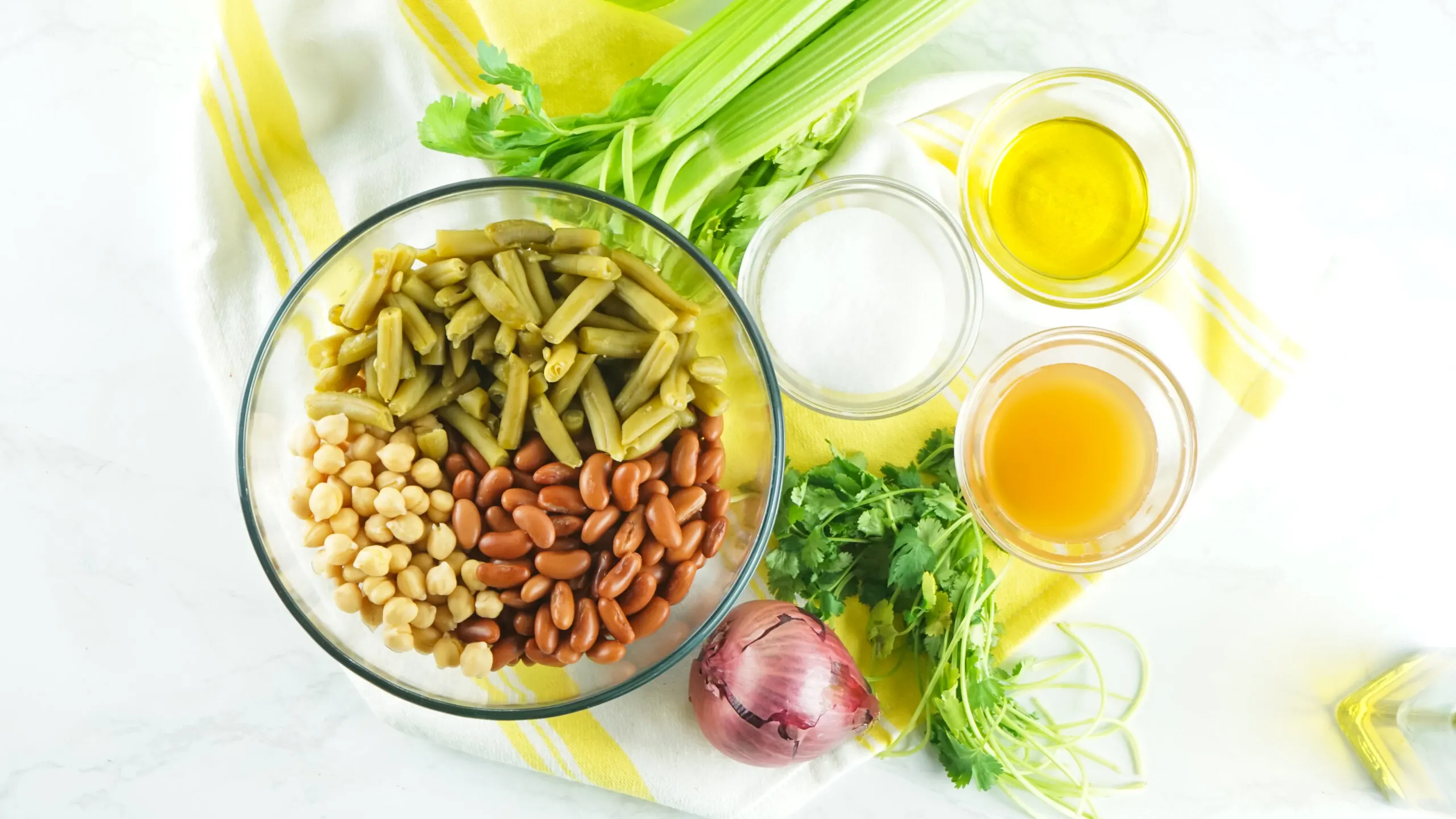 All 3 beans in a bowl with other ingredients laid around bowl.