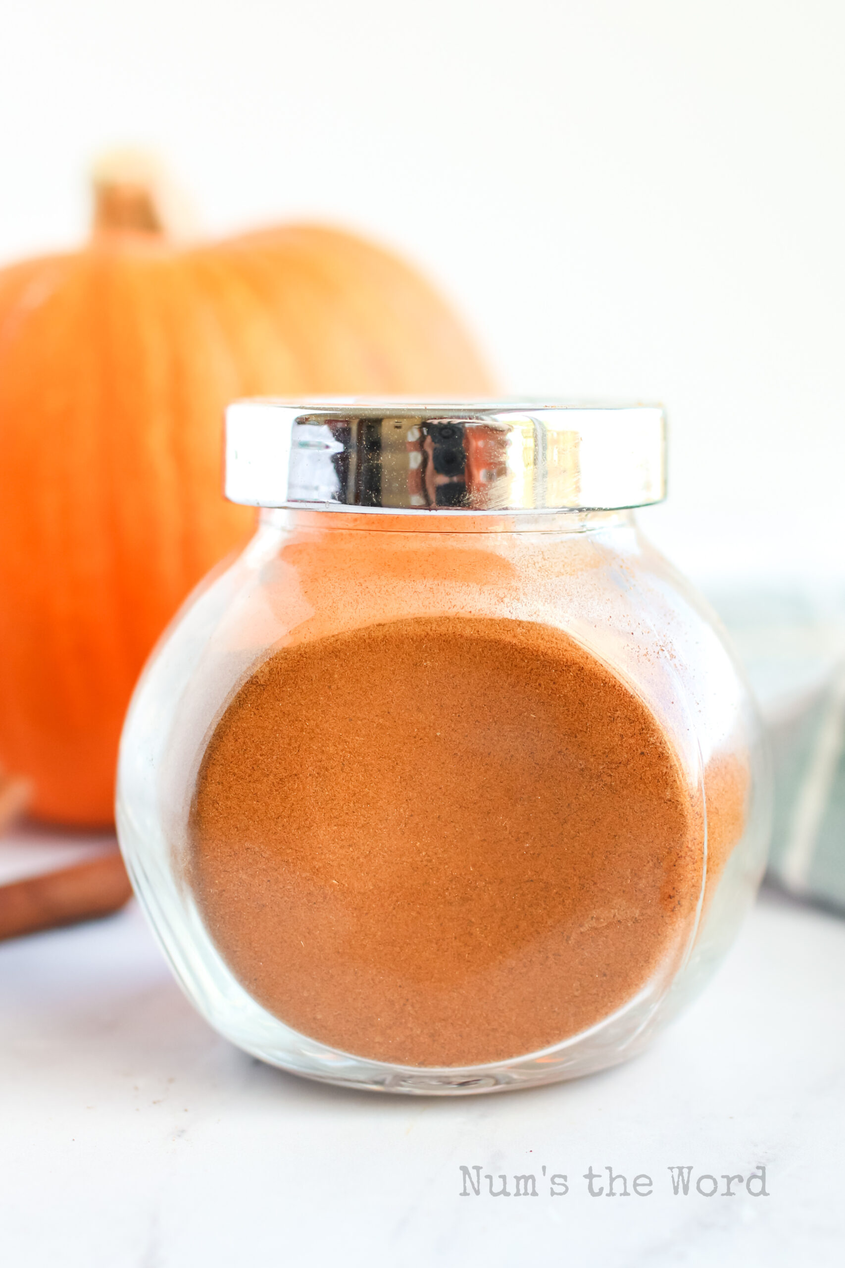 side view of pumpkin spice seasoning in a jar with lid on.