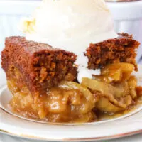 close up of gingerbread cake with apples and ice cream.