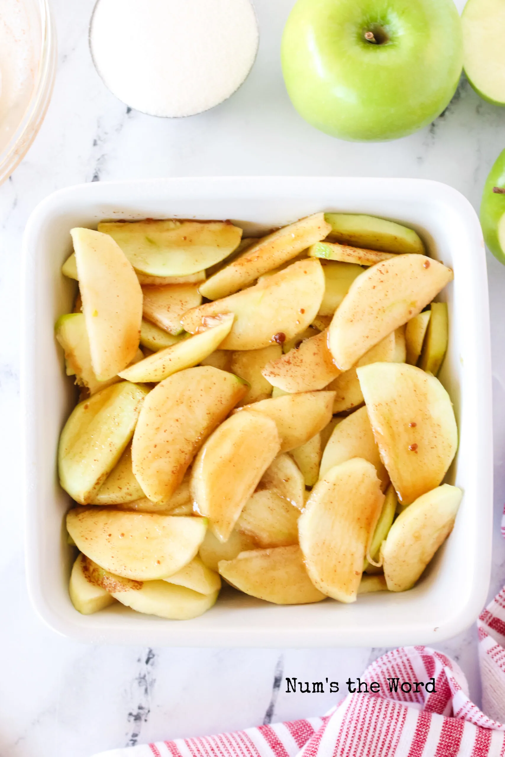 apples sliced and peeled in a casserole dish.