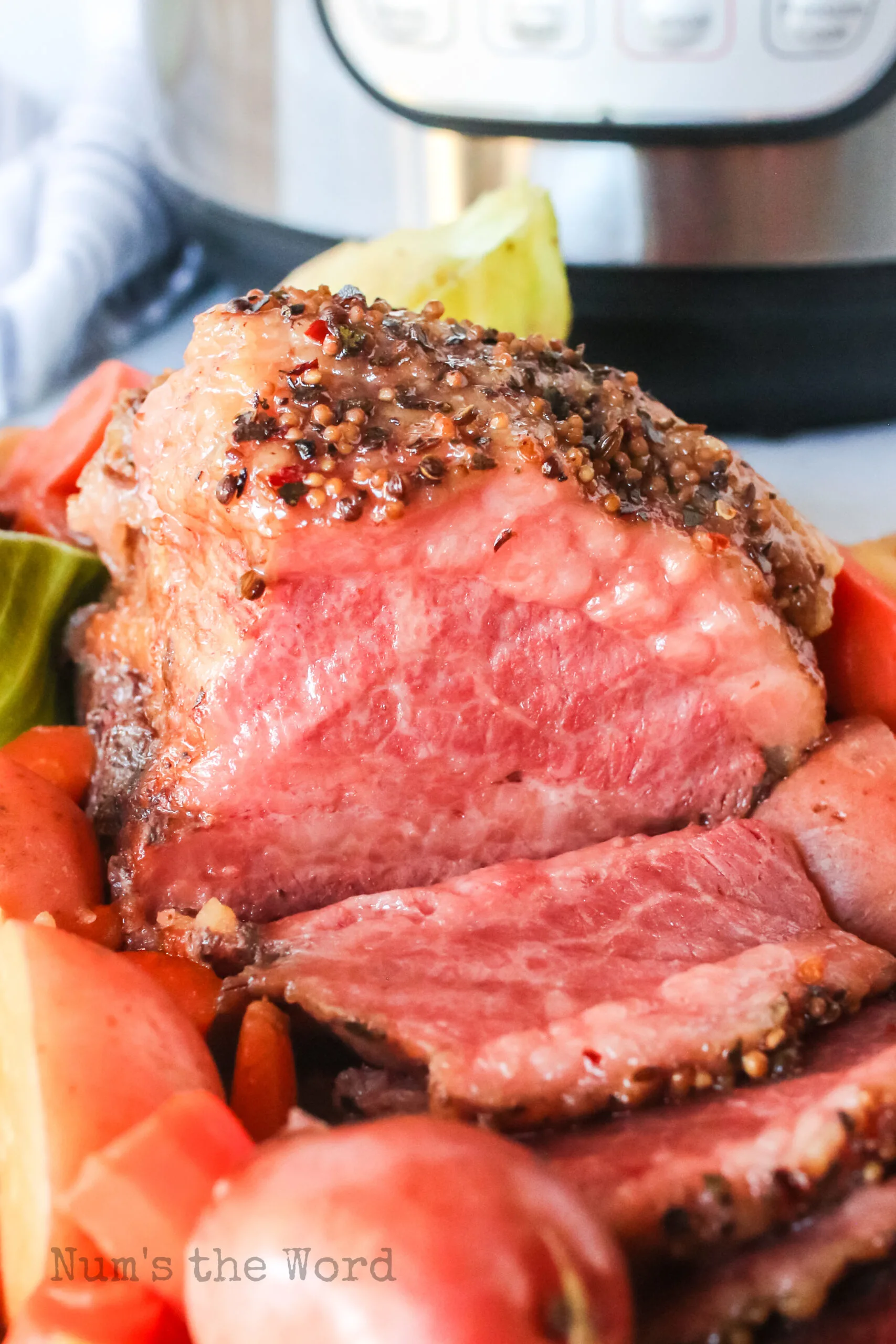 sliced corned beef on a platter with veggies