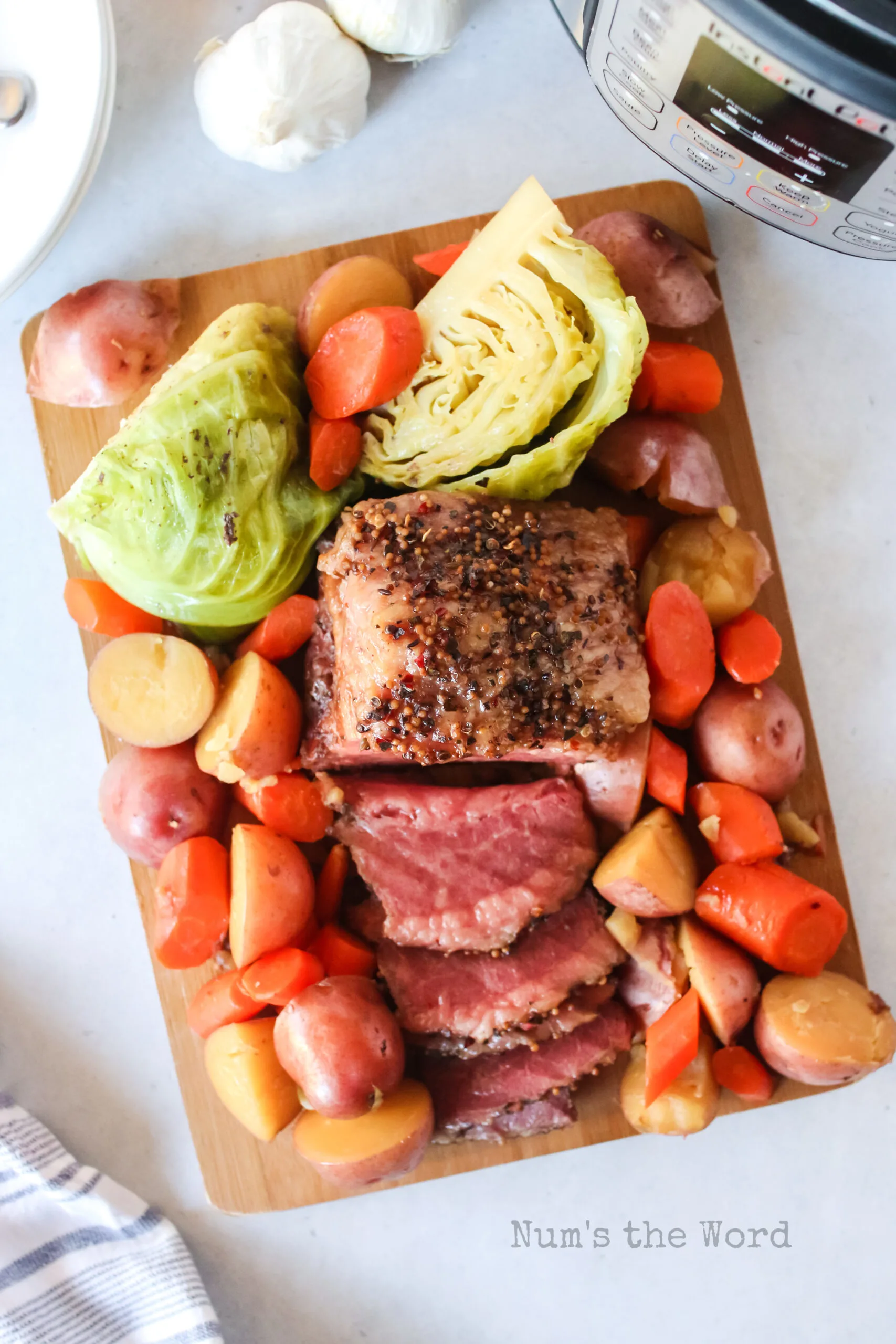 corned beef laid out on a cutting board with cabbage and veggies.