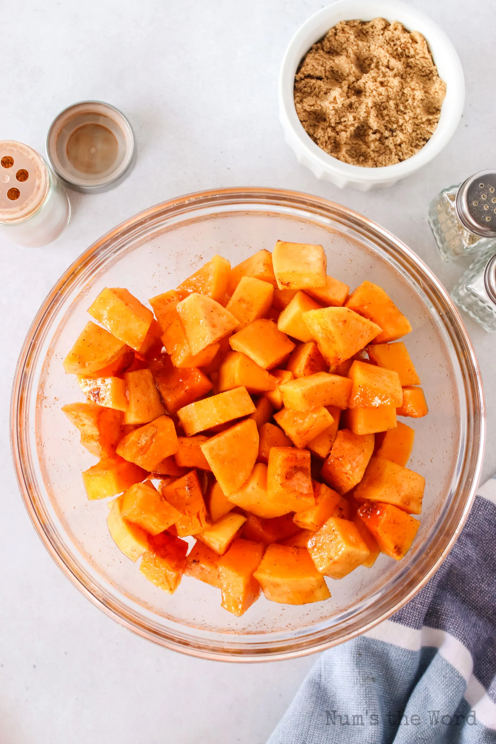 peeled and cut squash in a bowl with oil and seasoning.