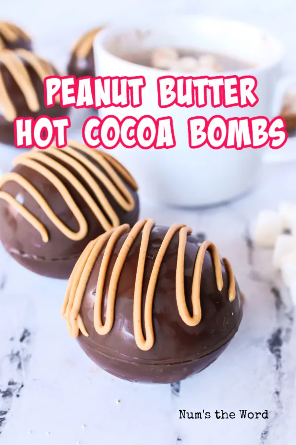 Main image for recie of two hot cocoa bombs made with one dissolved in a cup behind.