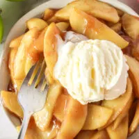 apples in bowl with scoop of ice cream and a fork in the apples.