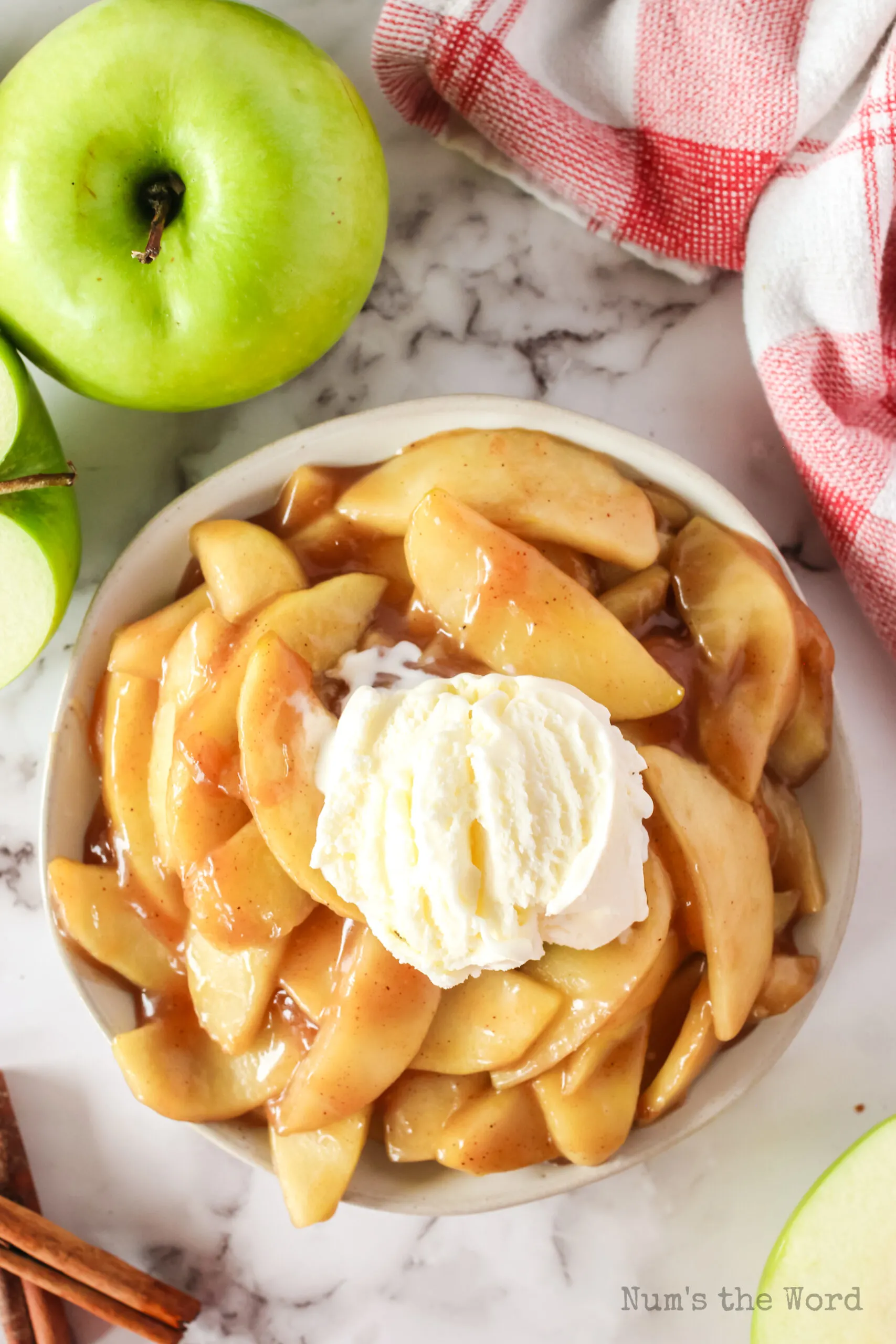 zoomed out image of apples in bowl with scoop of ice cream