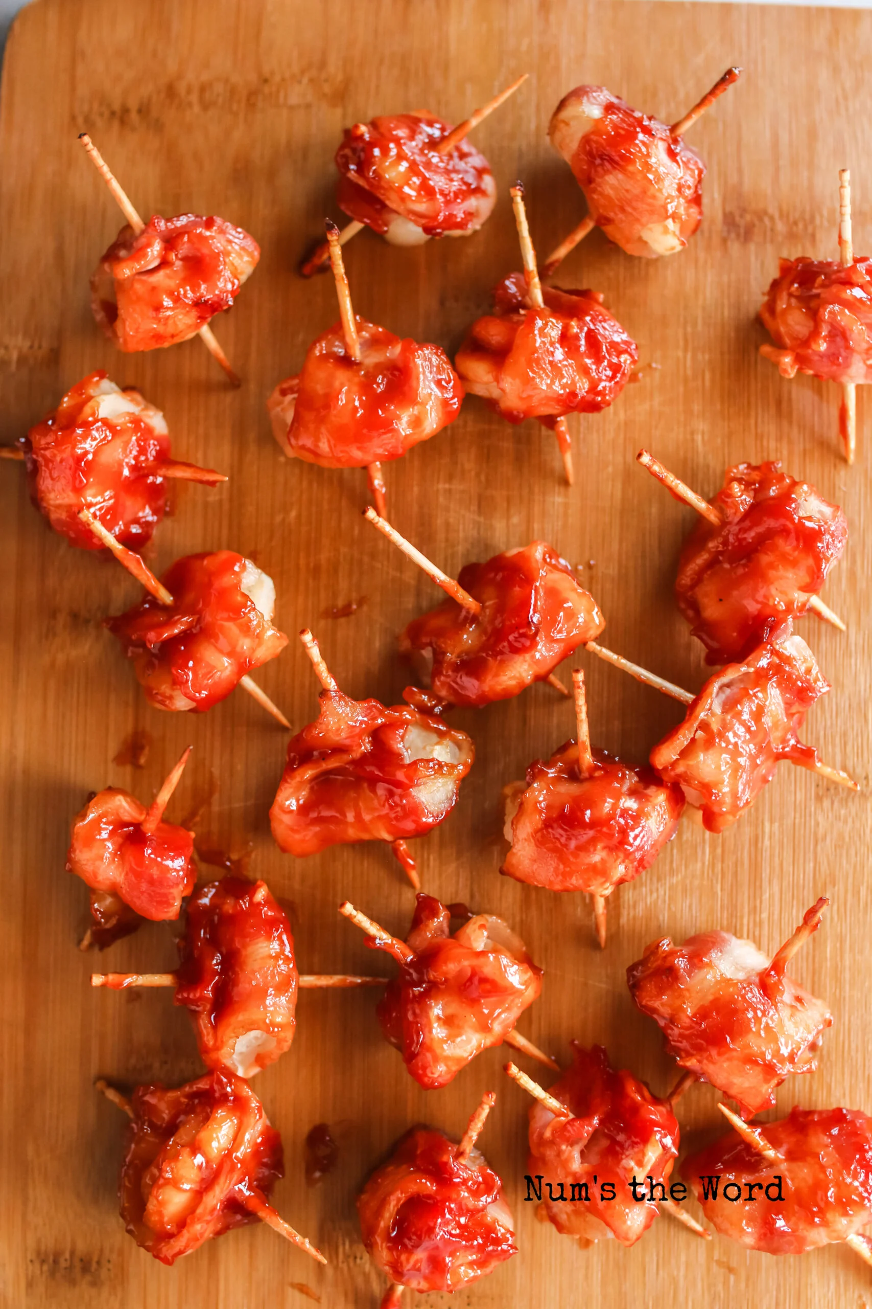 zoomed in image of bacon wrapped water chestnuts on a cutting board, ready to serve