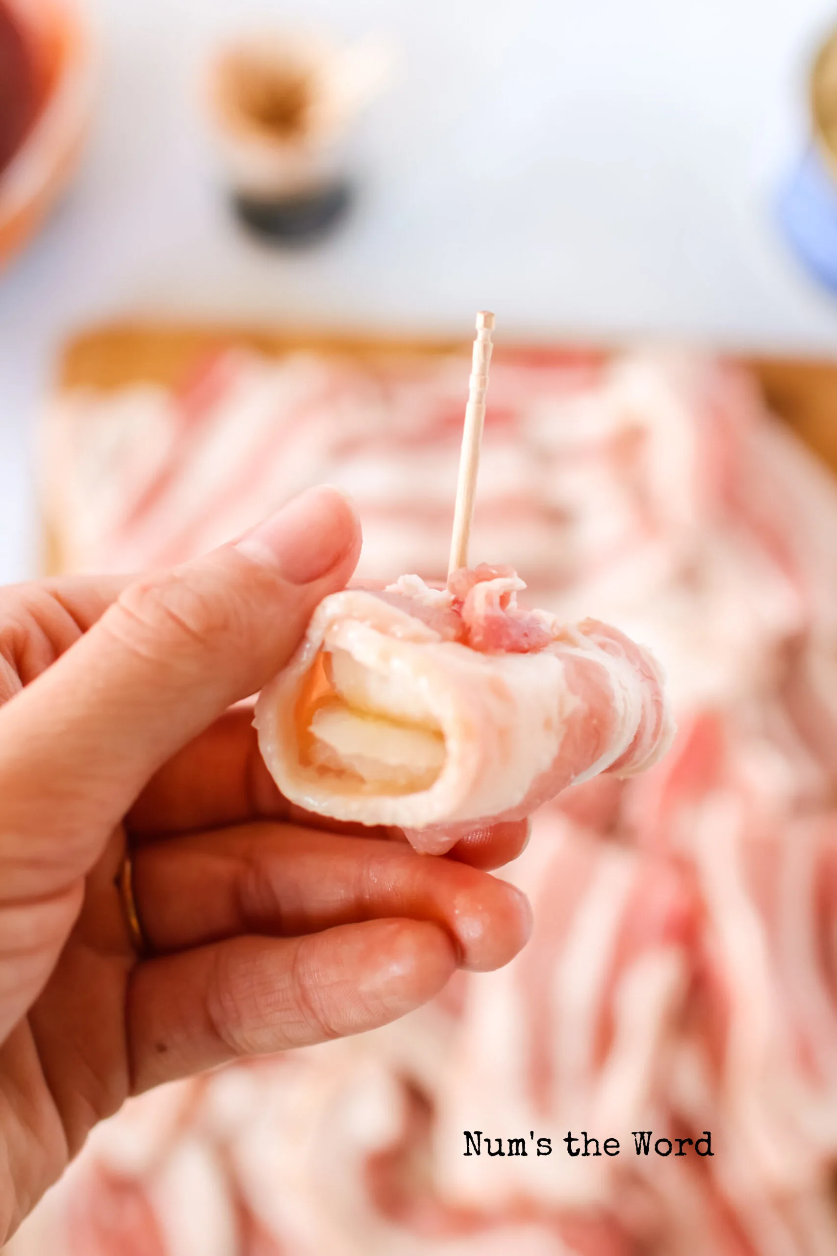 Bacon wrapped around two slices of water chestnut, secured with a toothpic, uncooked
