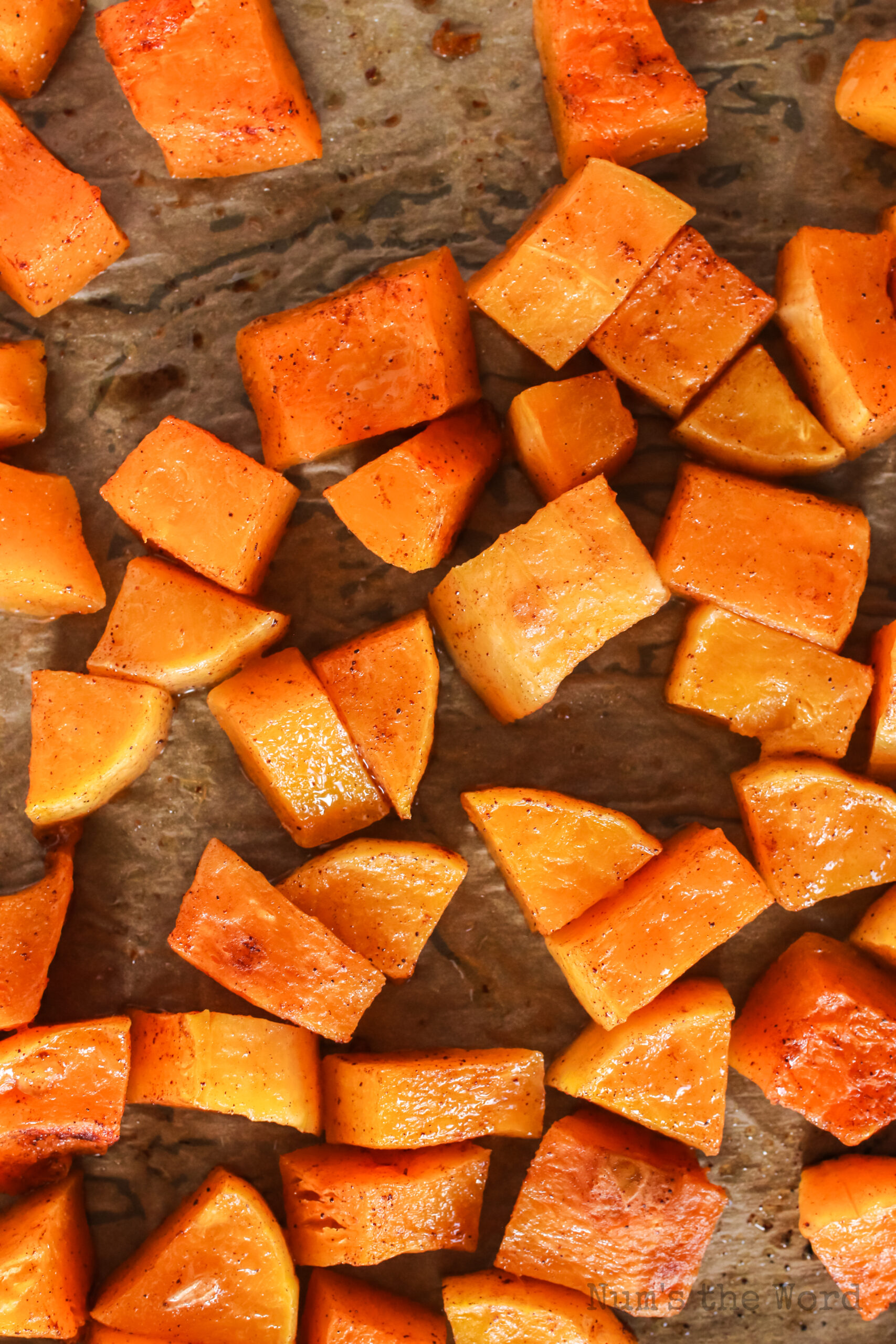 butternut squash on a lined cookie sheet, baked and ready to use in the salad.