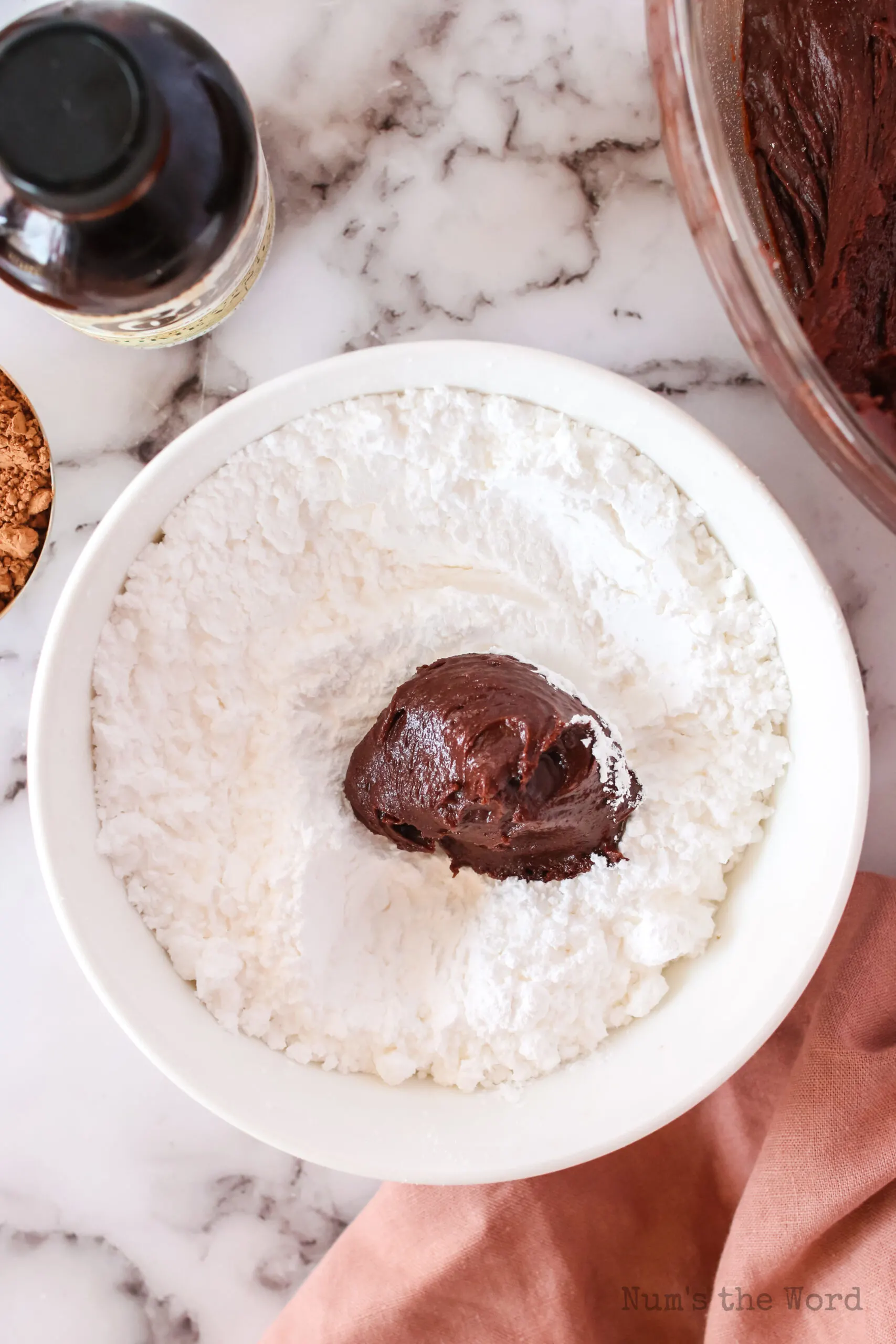 a ball of cookie dough in a bowl of powdered sugar., unrolled.