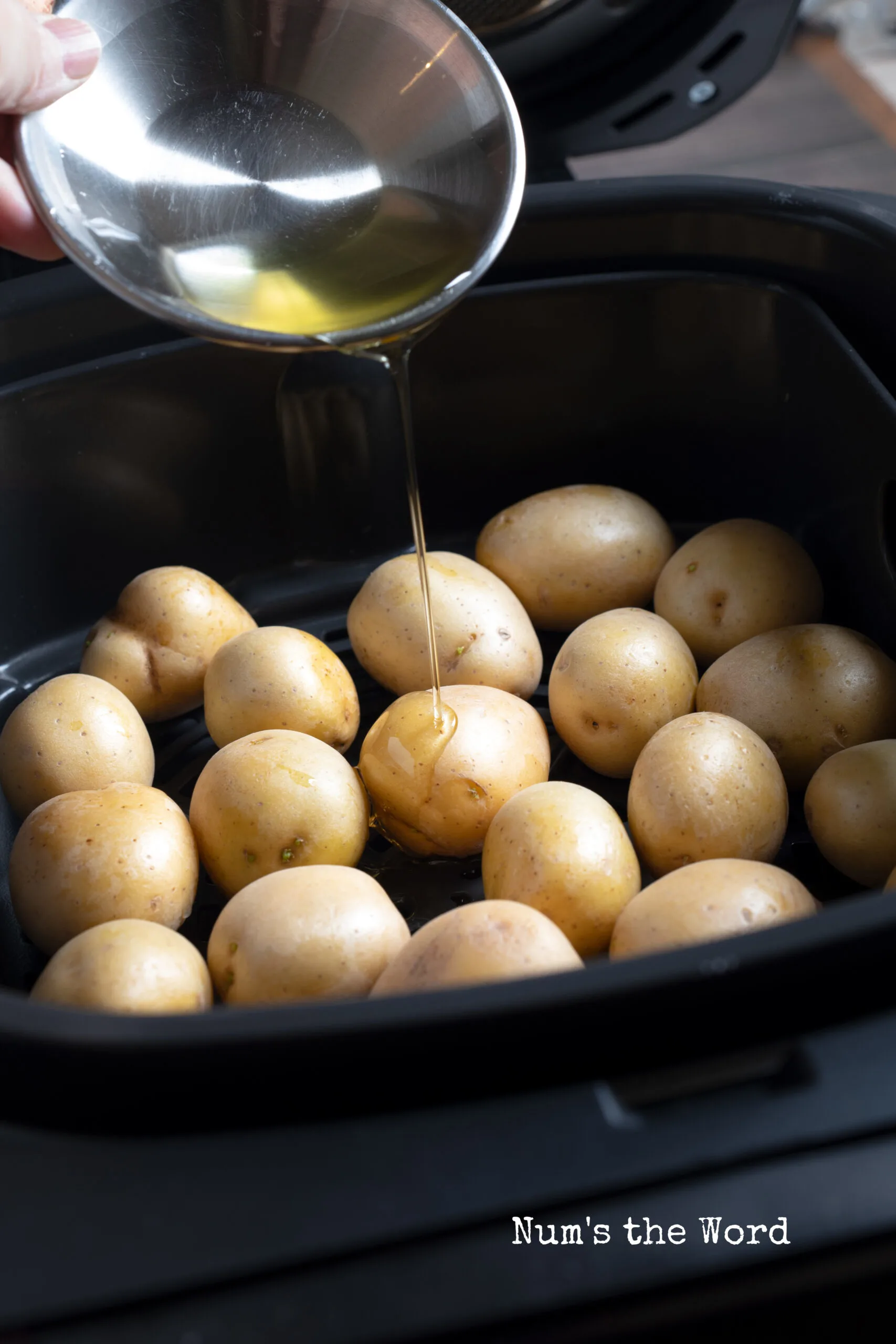 vegetable oil being drizzled on potatoes